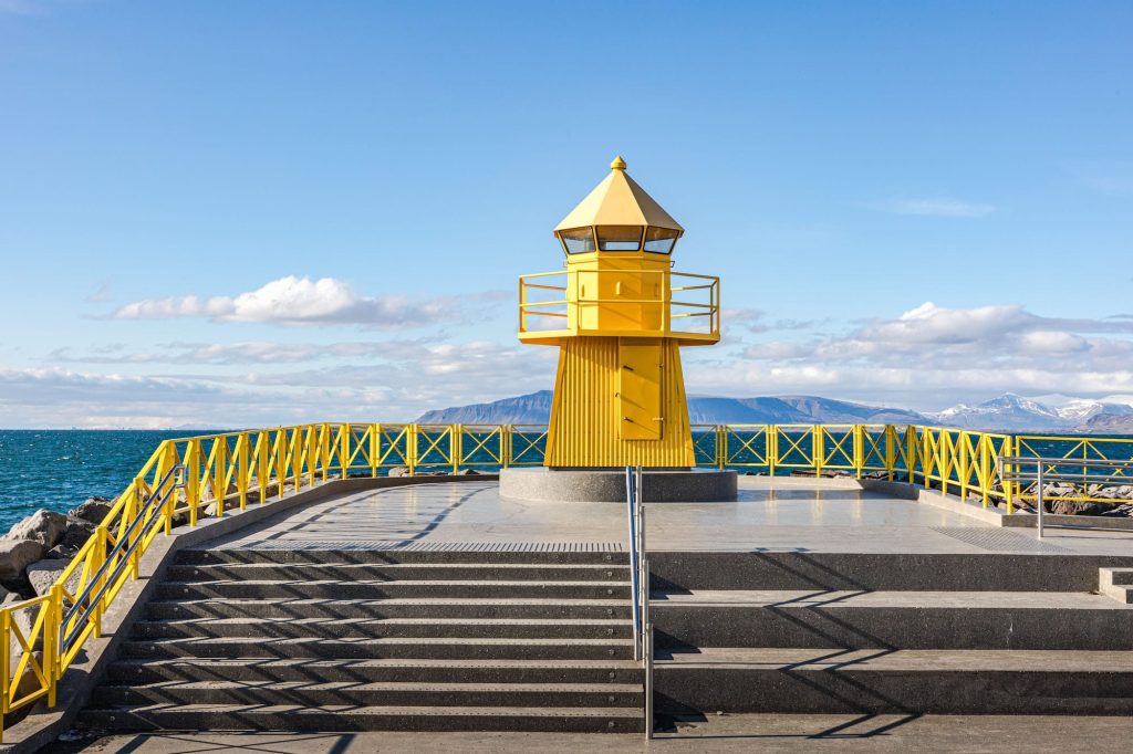 Historische gele vuurtoren op de rotsen van Reykjavik
